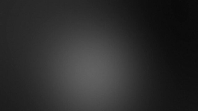 Dark grey abstract gradient background with soft studio vignette effect and central light glow