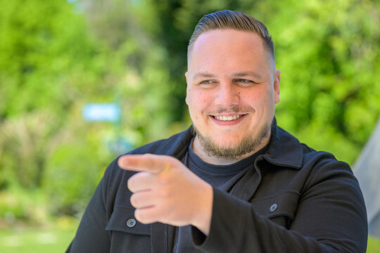 Smiling Man Pointing During Conversation