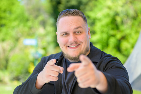 Playful Young Man Pointing Camera