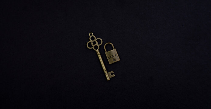 Vintage heart shaped key paired with a small lock reading love on a dark background, symbolizing romance, devotion, commitment, trust, and emotional connection.
