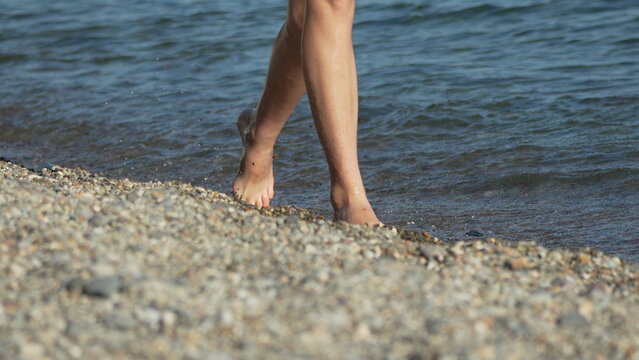 Legs, walking, beach, a person walking barefoot along the rocky shoreline during a sunny summer day at the ocean