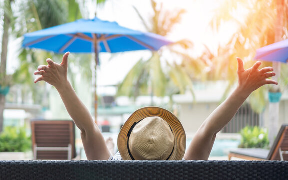 Summer resort hotel stay relaxation celebration. Woman take it easy happily resting on beach chair on holiday travel vacation peacefully at poolside, tropical beach swimming pool