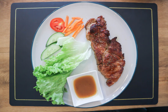 pork steak or grilled pork and salad or pork chop and vegetable