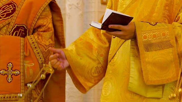 Priests swinging a golden censer in church.