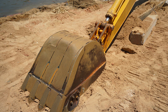 Building process city levee. Excavator dredging pond bank