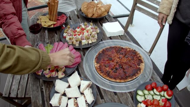 People Sharing Appetizers and Wine at Outdoor Social Gathering