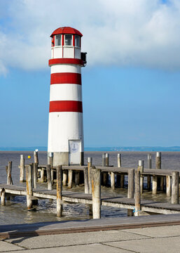 red and white stripped lighthouse on the shore of the sea