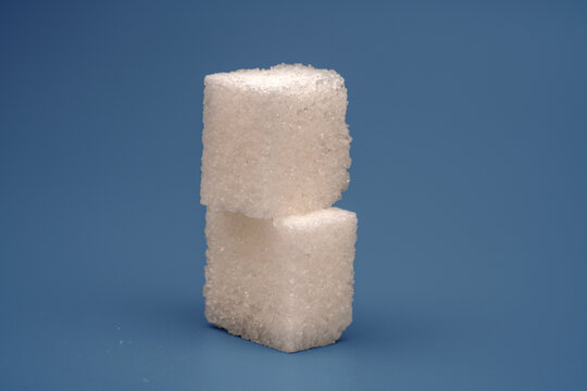 Sugar cubes stacked on a blue surface