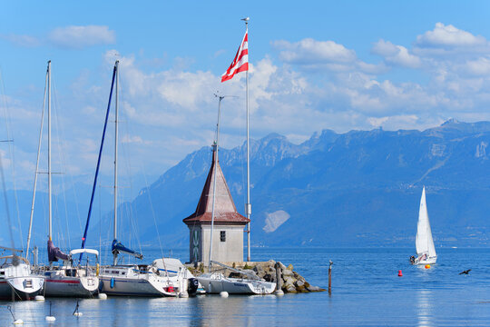 Morges, Switzerland - August 6, 2026: Sailboats Docked in Morges Harbor with Lake Geneva and Alps Background