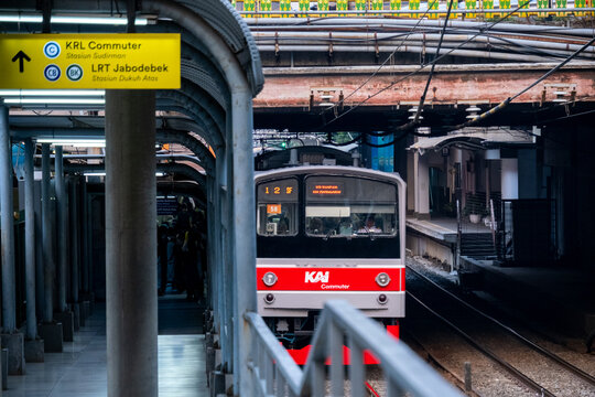 Jakarta, Indonesia - August 9, 2026: KAI Commuter JR 205 Series train departs beneath the Sudirman Street bridge.