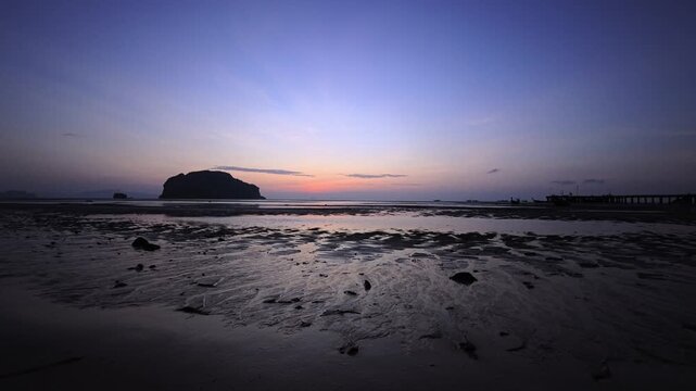 Sunrise on a paradisiacal sandy beach on a tropical island in Thailand at low tide
