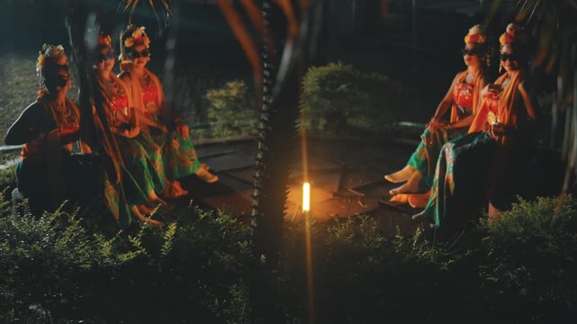 Group of Indonesian Dancers in Costume and Sunglasses Relaxing Outdoors at Night