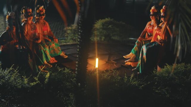 Indonesian Dancers in Traditional Attire and Sunglasses Chatting at Night