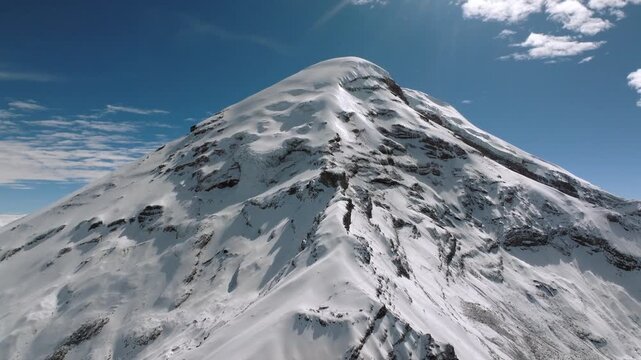 Aerial Shot of Majestic Snow Covered Volcano Summit Under Blue Sky