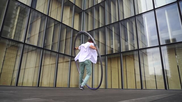Dynamic and vibrant performance of a Cyr Wheel within urban architecture. Concept of individuality, creativity and self-confidence