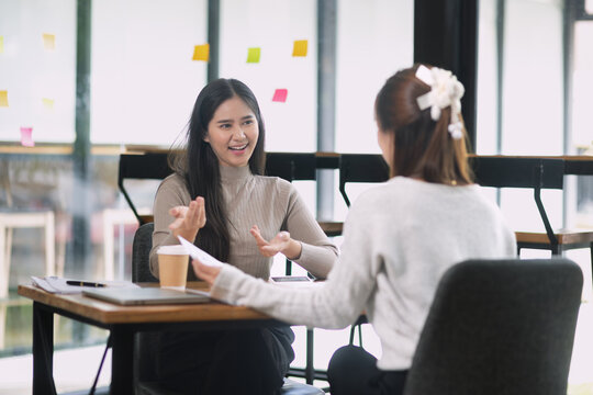 Two young Asian businesswomen are having a conversation and during a job interview in office.