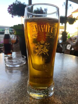 Glas polnisches Żywiec Bier auf einem Restauranttisch im Biergarten. Erfrischendes helles Lager/Pilsner, Gastronomie, Sommer, polnische Bierkultur und authentische Restaurantaufnahme.