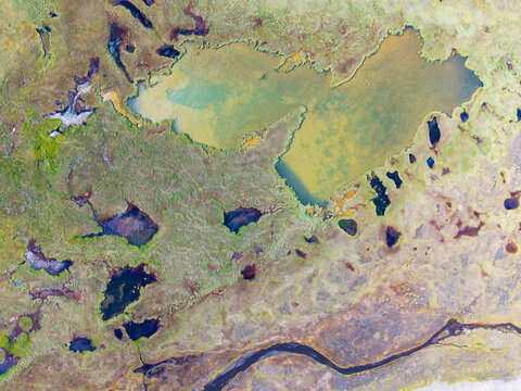 Aerial view of the diverse Icelandic landscape featuring small lakes, ponds, and winding streams Iceland.