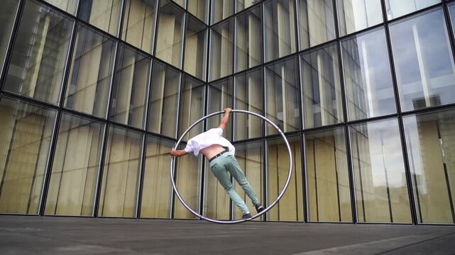 Dynamic and vibrant performance of a Cyr Wheel within urban architecture. Concept of originality, creativity and outstanding