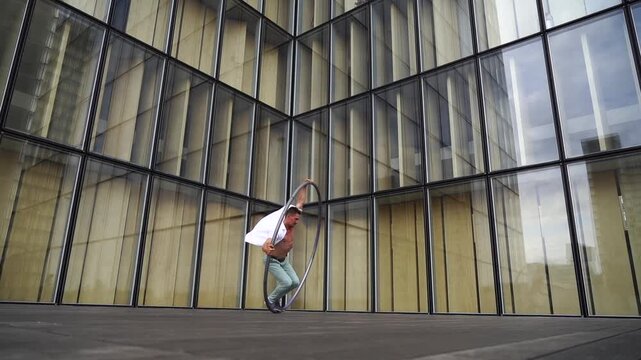 Dynamic and vibrant performance of a Cyr Wheel within urban architecture. Concept of expression, freedom, passion and potential