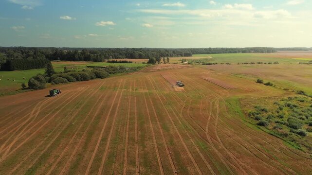 Agricultural machinery harvesting wheat in expansive fields, showcasing the continuous process of threshing and collecting crops under a clear blue sky