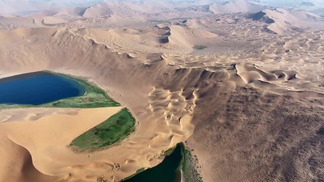 Turquoise Oasis Lake Surrounded by Golden Sand Dunes in Badain Jaran Desert, China
