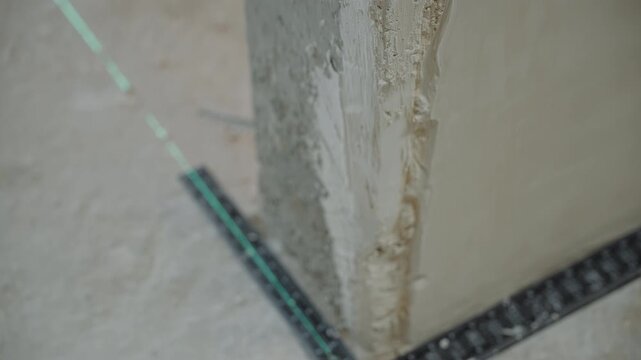 Close up of plastered wall edge with laser leveling line