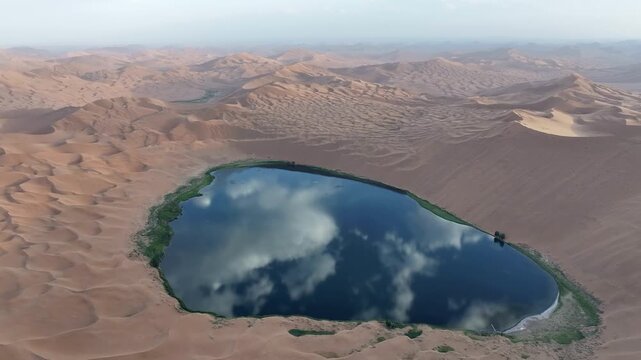 Turquoise Oasis Lake Surrounded by Golden Sand Dunes in Badain Jaran Desert, China
