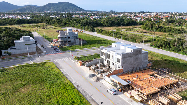 Aerial view of modern houses under construction using pre-cast concrete elements with workers on site in Florianopolis, Santa Catarina, Brazil.