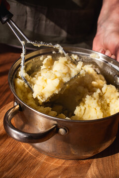 Potato Masher Pressing Through Soft Boiled Potato Texture