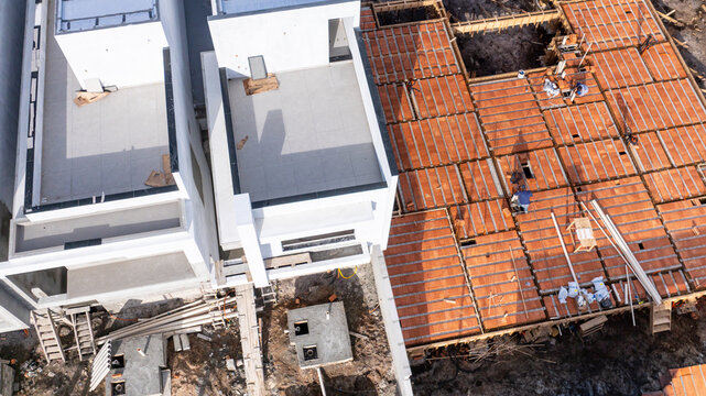 Aerial view of modern houses under construction with pre-cast concrete elements and workers on the site in Florianopolis, Santa Catarina, Brazil.