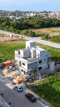 Aerial view of a modern house under construction using pre-cast concrete elements with workers on site in Florianopolis, Santa Catarina, Brazil.