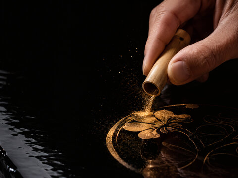 Artisan Hand Sprinkling Gold Powder onto Black Lacquer, Precision Craftsmanship and Luxury Manufacturing Branding, Copy Space