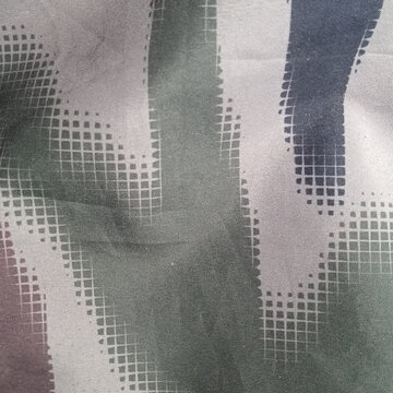 Camouflage pattern with grid and speckled elements close up textile view