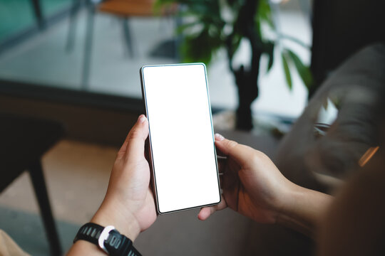Close-up of user hands holding smartphone with blank white screen mockup for mobile application design or website template display.