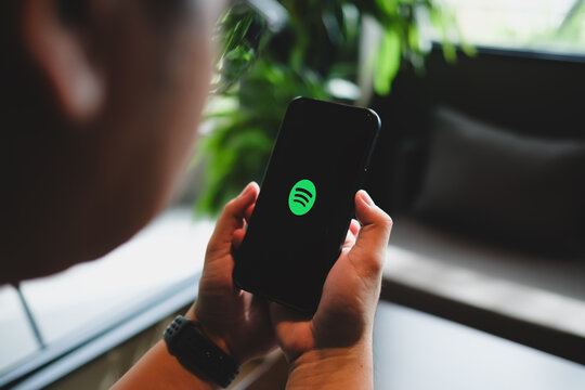 Bangkok, Thailand. August 16, 2026; Person holding smartphone displaying Spotify music streaming application logo on screen.