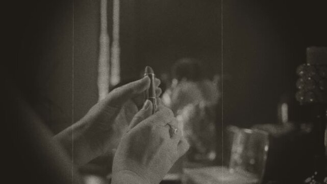 Black and white film color old style silhouette person close-up body part, girl hands put forward twistes open rotetes lipstick, long-lasting cosmetics, gloss make up. woman preparing holiday makeup