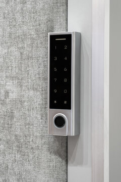 Modern electronic keypad door lock with numeric touch panel and fingerprint sensor installed on a contemporary interior door, smart home security technology