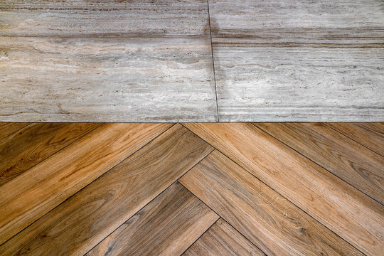 Contemporary interior floor detail featuring beige travertine-style stone tiles meeting warm natural wood parquet arranged in a classic herringbone pattern