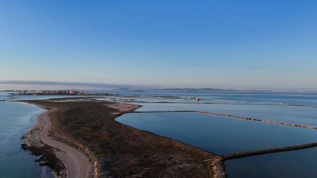 A drone view of the Las Salinas de San Pedro del Pinatar Regional Park, in the Region of Murcia, Spain, with the Mar Menor in the background.