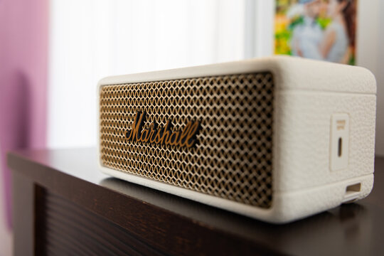  Side view of Marshall Emberton III cream wireless bluetooth speaker on dark wooden cabinet in cozy home interior