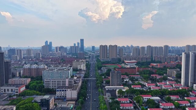 Aerial panoramic city view of mixed‑use urban area with main road running through downtown