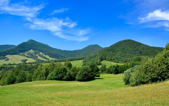 Beautiful summer landscape in the mountains with green meadows and forested hills. View of Mountain Lackowa (997 msl) in Low Beskids. (Beskid Niski).