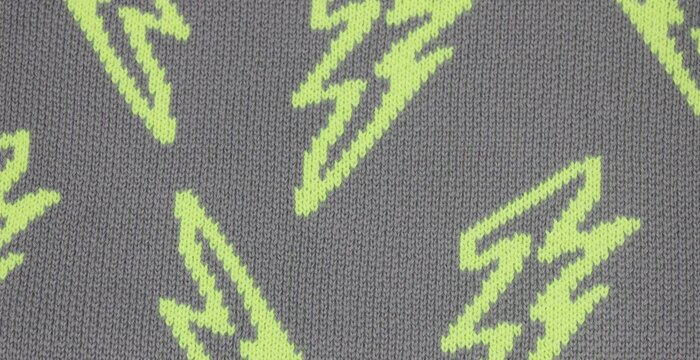Neon lightning bolt pattern on gray knitted fabric texture background for energetic concepts