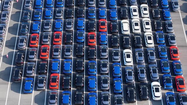 Aerial top‑down view of massive new car storage lot with neatly arranged vehicles	