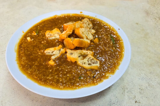 Close-up of a bowl of fried rice porridge or congee with fried bread stick or you tiao garnish, popular comfort food in Klang, Malaysia