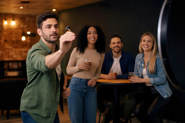 Fototapeta premium Friends Playing Darts in Warm Indoor Setting