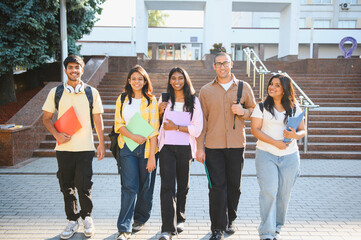 Obraz premium Group of diverse indian students walking on university campus