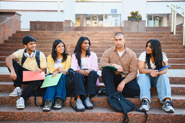 Fototapeta premium Indian students resting on university campus stairs
