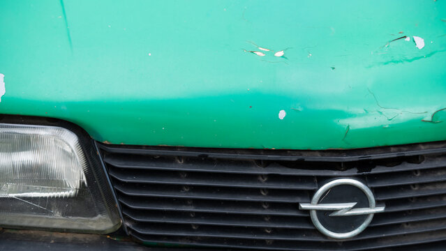 Front grille of a classic Opel Ascona displaying the original emblem, aged green paint and recognizable European styling, highlighting vintage automotive identity and classic car culture